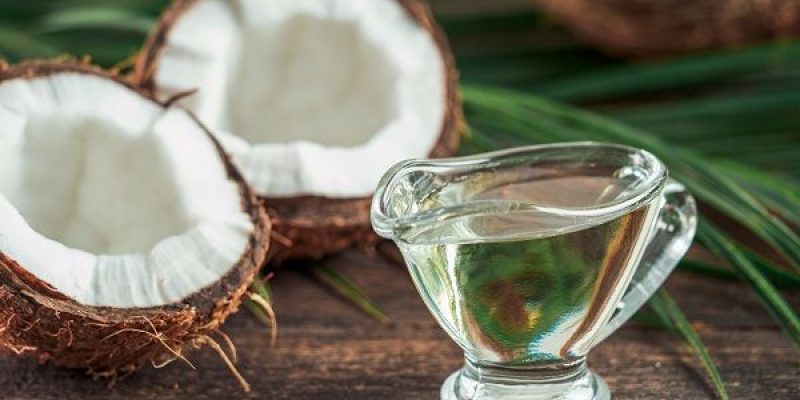 Liquid coconut MCT oil and halved coco-nut on wooden table. Health Benefits of MCT Oil. MCT or medium-chain triglycerides, form of saturated fatty acid.